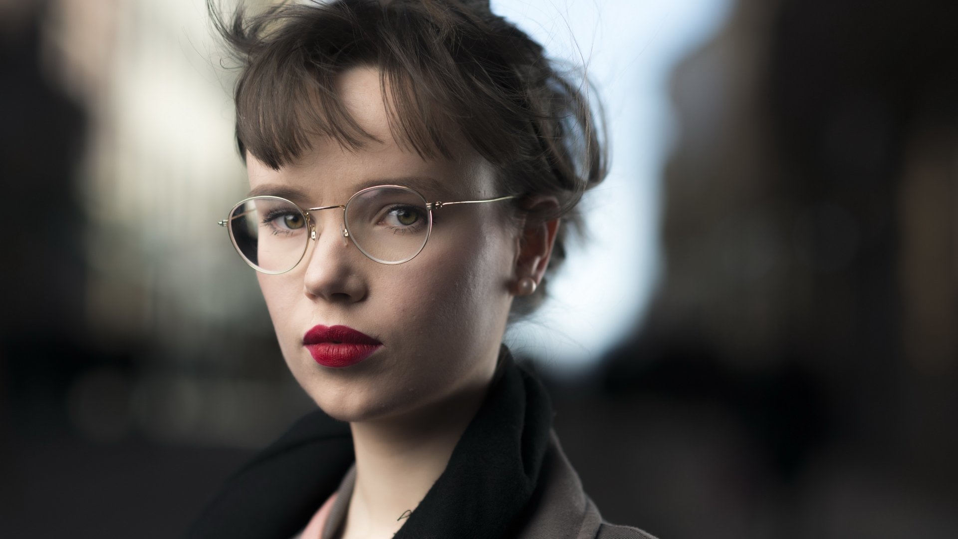 4K Ultra HD PC wallpaper: close-up portrait of a woman with glasses and red lipstick, her face framed against a soft bokeh city background.