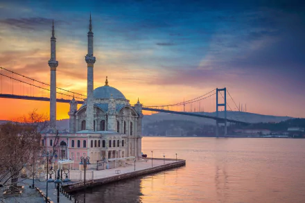 Ortaköy Mosque by the Bosphorus at sunrise with the Bosphorus Bridge behind — 2K Quad HD PC desktop wallpaper showcasing Istanbul's waterfront religious landmark.