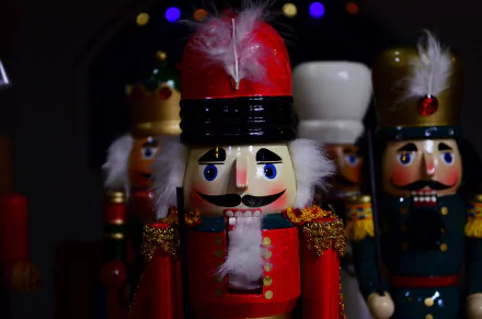 Painted nutcracker toy soldiers and glowing Christmas ornaments against a dark holiday scene — 4K Ultra HD PC desktop wallpaper/background.