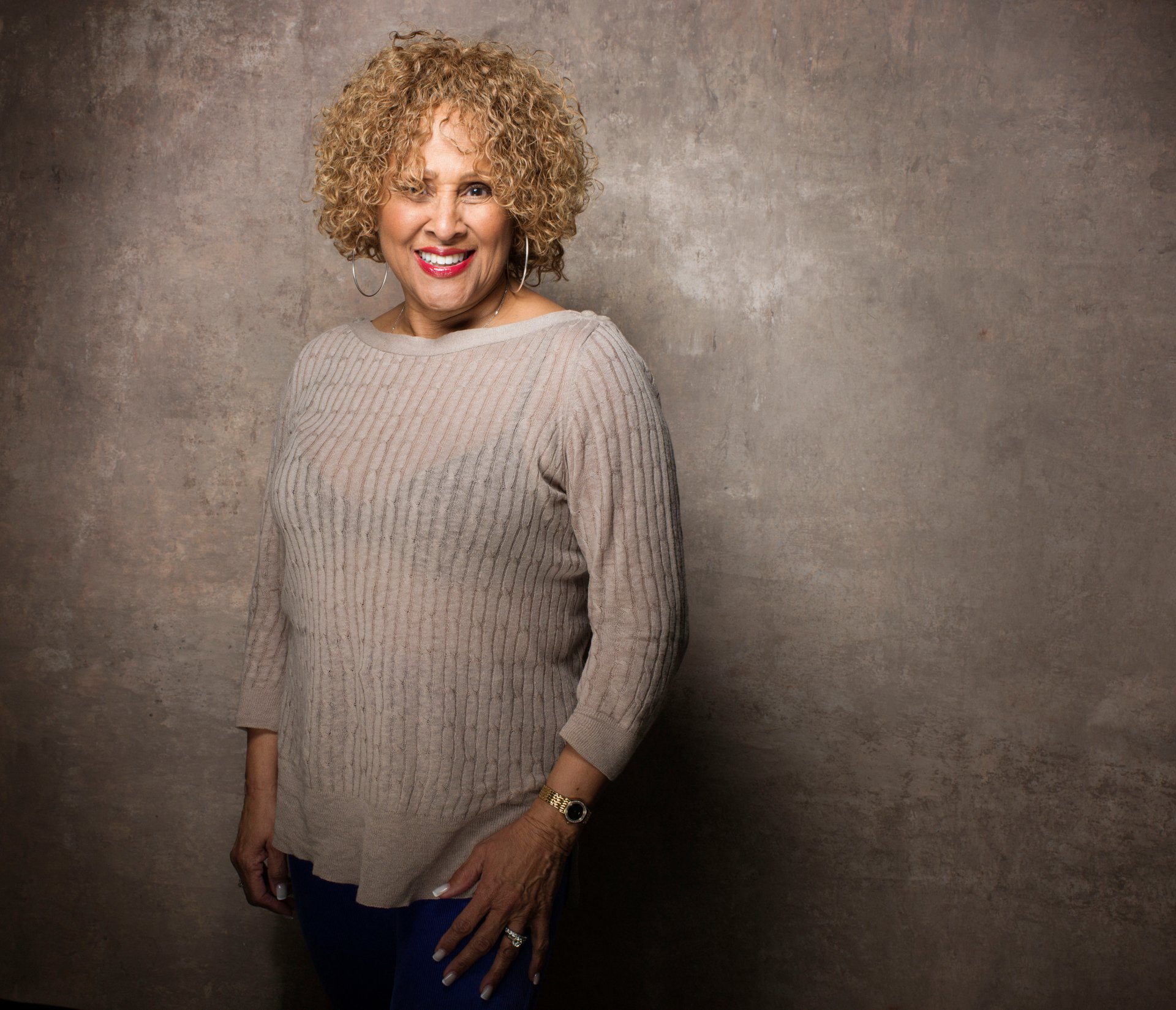 Darlene Love smiling in a beige sweater, a professional HD desktop wallpaper background.