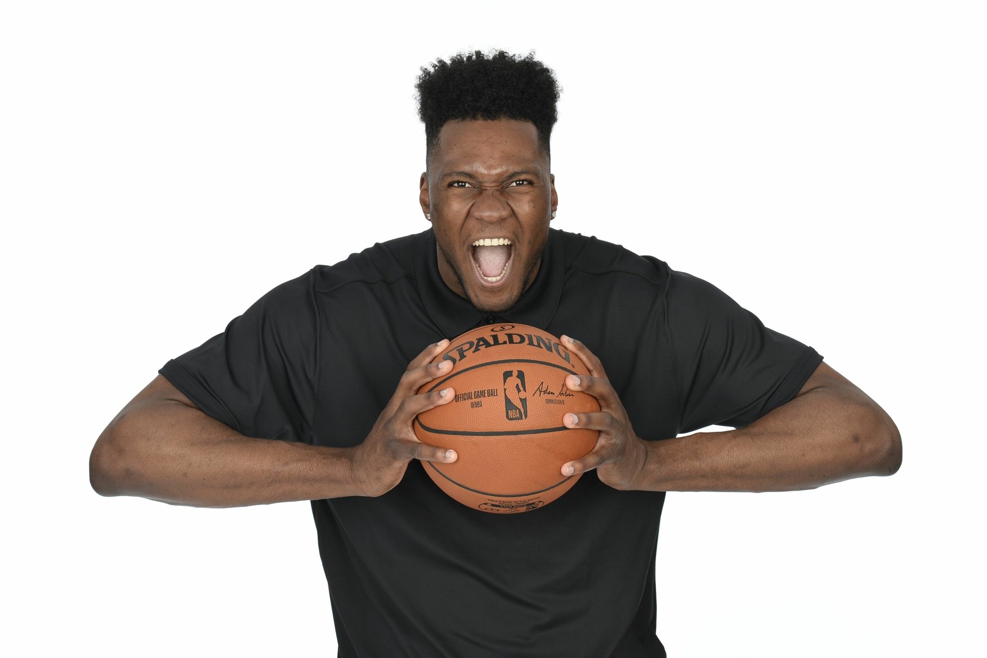 HD wallpaper of a basketball player in a black jersey holding a basketball with a fierce expression, against a white background.