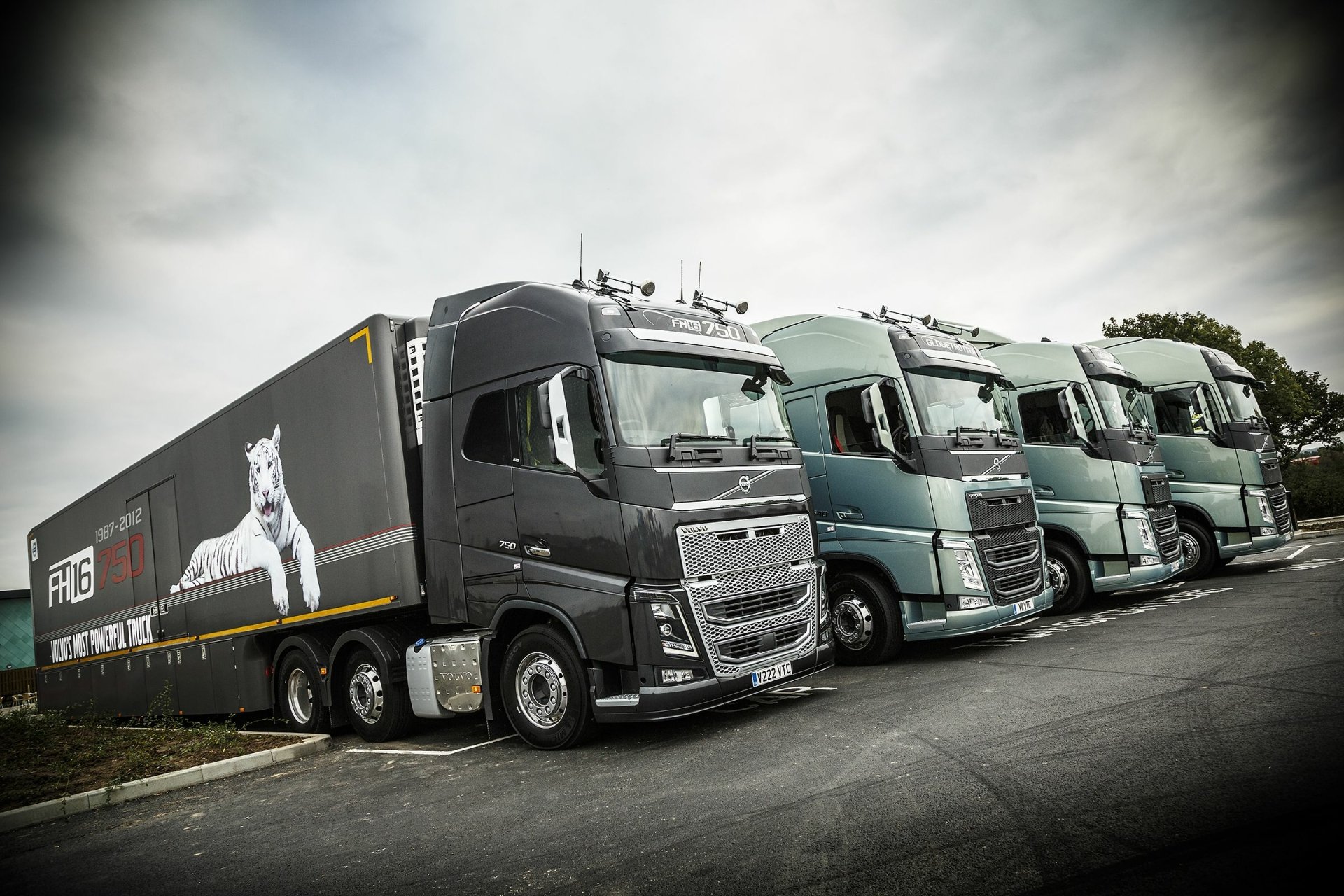 HD desktop wallpaper of a lineup of Volvo FH16 750 trucks ready for the road.