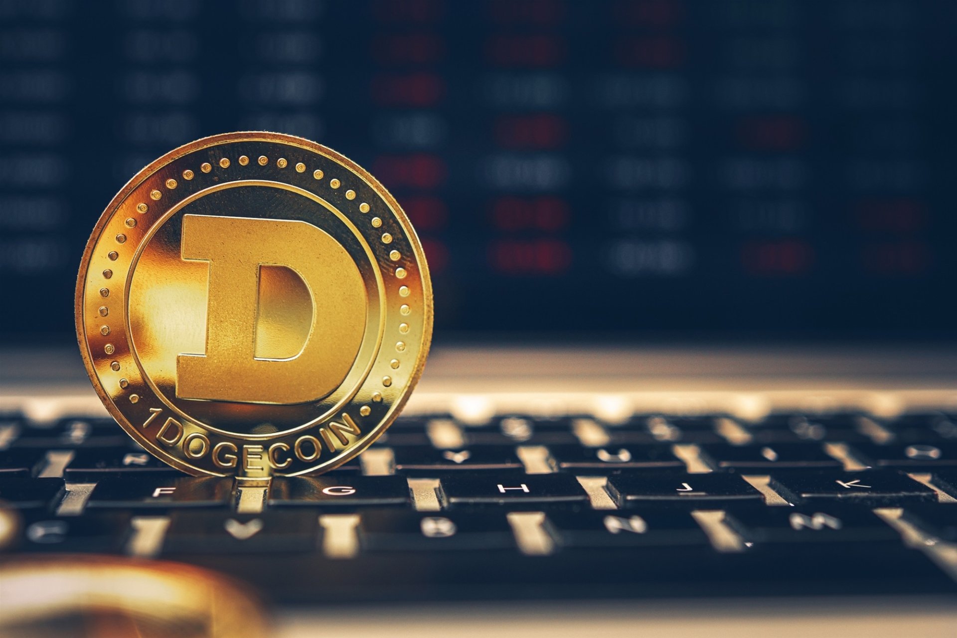 HD desktop wallpaper featuring a golden Dogecoin on a computer keyboard, symbolizing cryptocurrency.