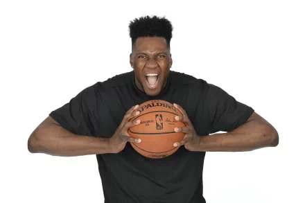 HD wallpaper of a basketball player in a black jersey holding a basketball with a fierce expression, against a white background.