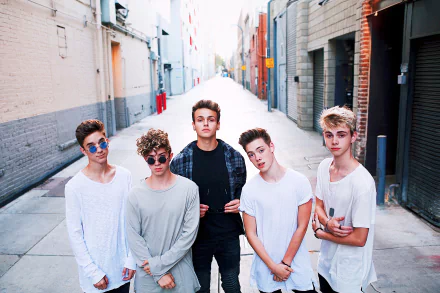 HD desktop wallpaper featuring the band Why Don't We, with members posing in an urban alleyway.