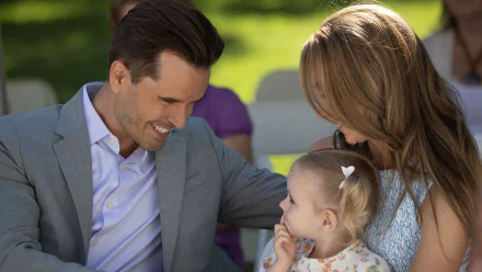 HD desktop wallpaper from Heartland featuring a smiling man and woman adoring a toddler.