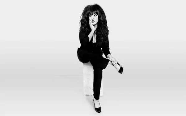 HD desktop wallpaper featuring a monochrome photo of a member of The Ronettes posing with a vintage microphone, styled in 60s fashion.