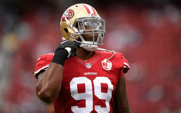 HD desktop wallpaper featuring DeForest Buckner in a red 49ers uniform, poised on the field with helmet in hand.