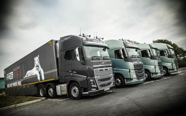 HD desktop wallpaper of a lineup of Volvo FH16 750 trucks ready for the road.
