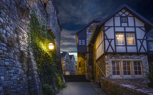 4K Ultra HD PC desktop wallpaper: man-made stone and half-timbered houses lining a lantern-lit cobblestone lane under a starry night sky.