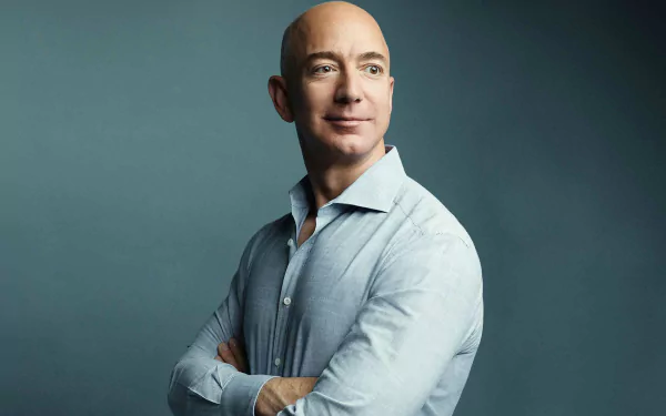 HD desktop wallpaper featuring a person with arms crossed and a confident smile, set against a grey background.