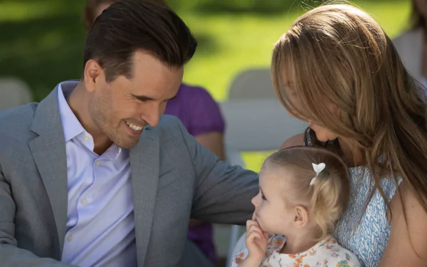 HD desktop wallpaper from Heartland featuring a smiling man and woman adoring a toddler.