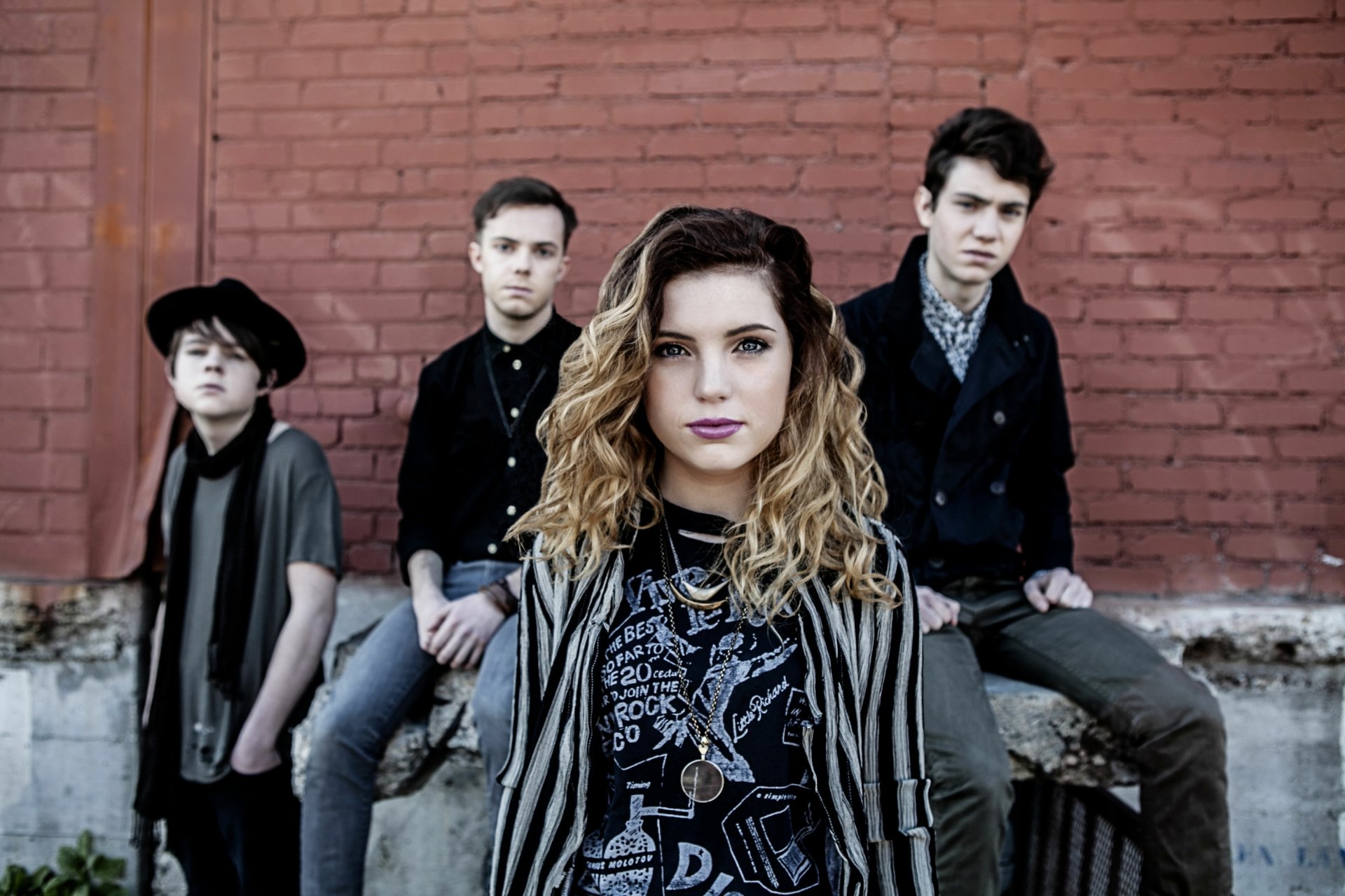 HD desktop wallpaper of Echosmith with Sydney Sierota at the front, posing in front of a red brick wall.