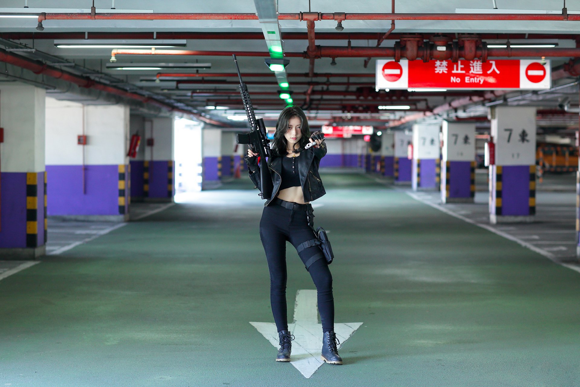 A confident Asian woman with black hair poses holding a gun in a dimly lit parking garage, captured in sharp focus with a blurred background in 4K Ultra HD.