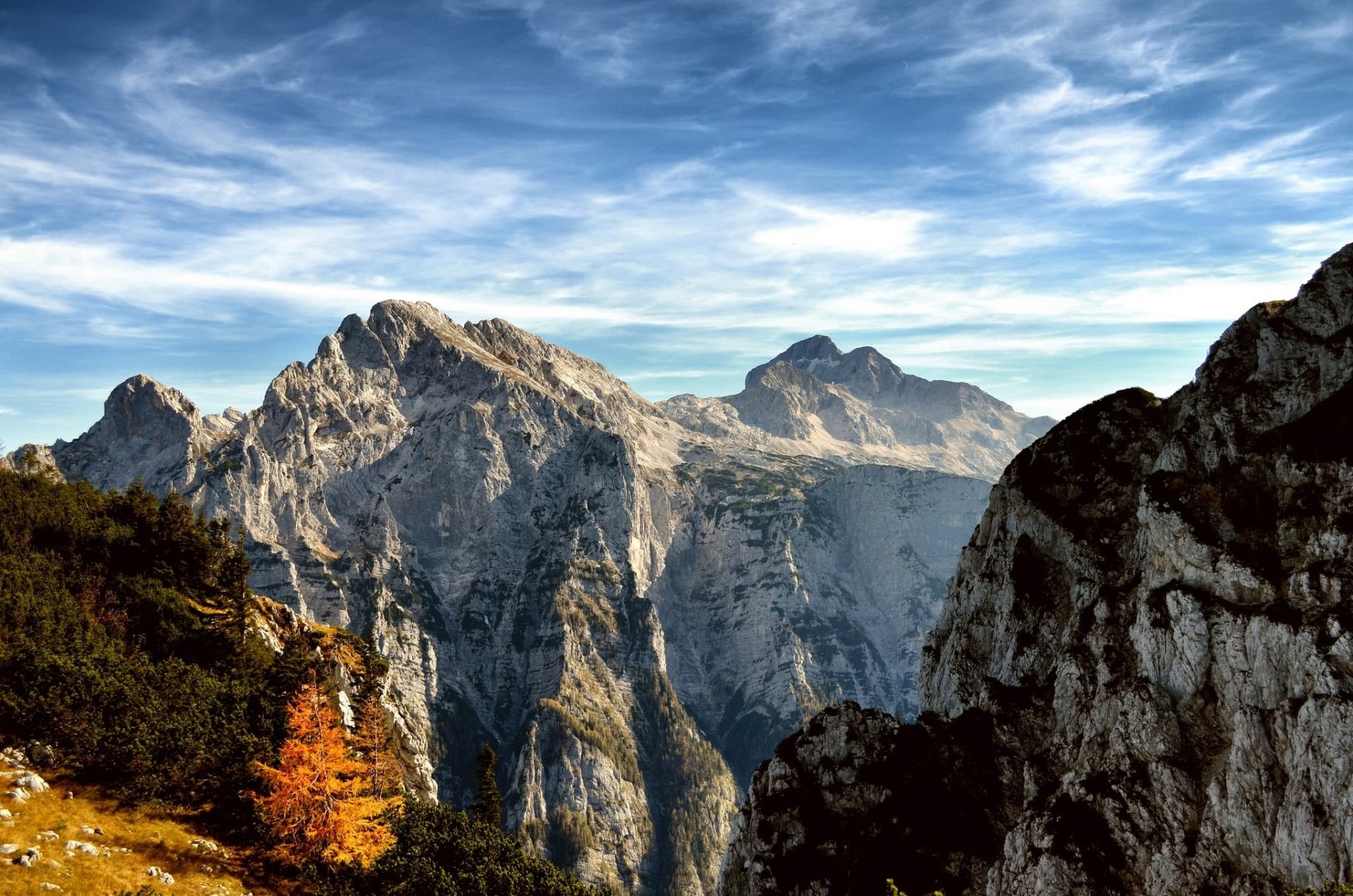 HD PC desktop wallpaper showcasing a stunning mountain landscape with rugged peaks under a vibrant blue sky, surrounded by nature's autumn colors.