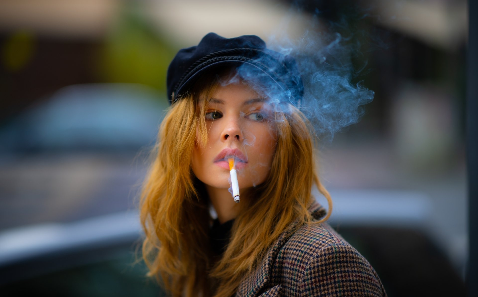 Blonde Russian model Anastasiya Scheglova wearing a hat, smoking a cigarette with a blurred background, captured in 8K Ultra HD with depth of field.