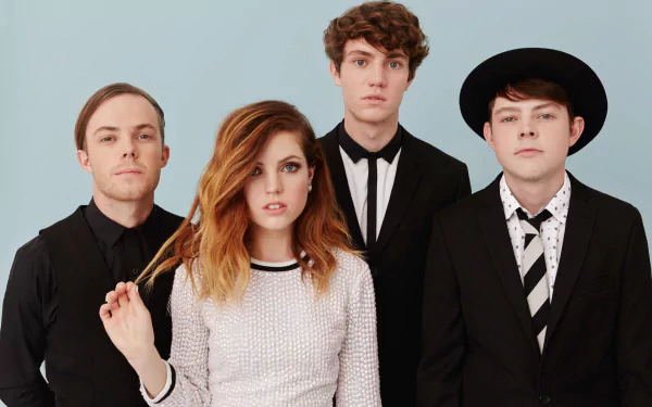HD wallpaper of Echosmith with Sydney Sierota, depicting the band members in stylish black and white attire against a blue backdrop.