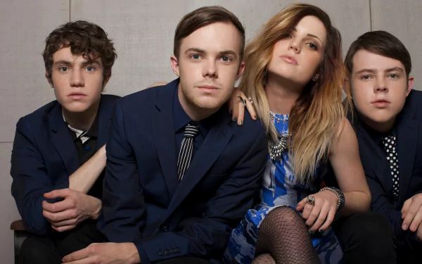 HD desktop wallpaper of Echosmith with Sydney Sierota posing with band members in formal attire.