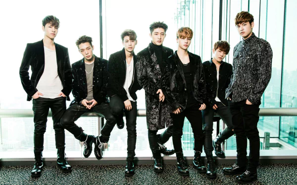 HD desktop wallpaper featuring the group iKON in stylish outfits, standing together against a glass backdrop with a city view.
