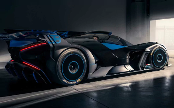 HD wallpaper of a Bugatti Bolide with a sleek black and blue design, poised in a dimly lit garage.