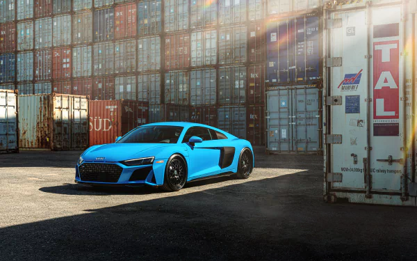 Blue Audi R8 supercar parked beside stacked shipping containers, high-detail 8K Ultra HD PC desktop wallpaper background.