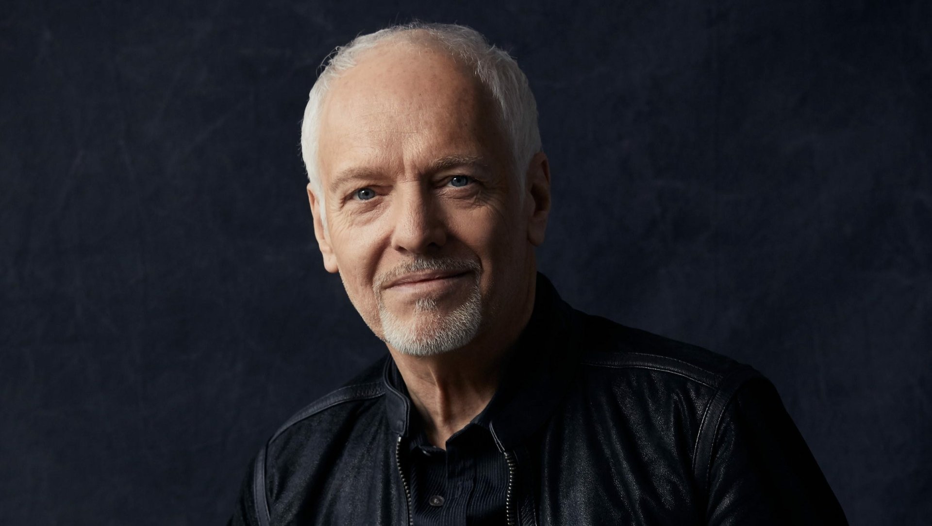 HD desktop wallpaper featuring a portrait of Peter Frampton against a dark background.