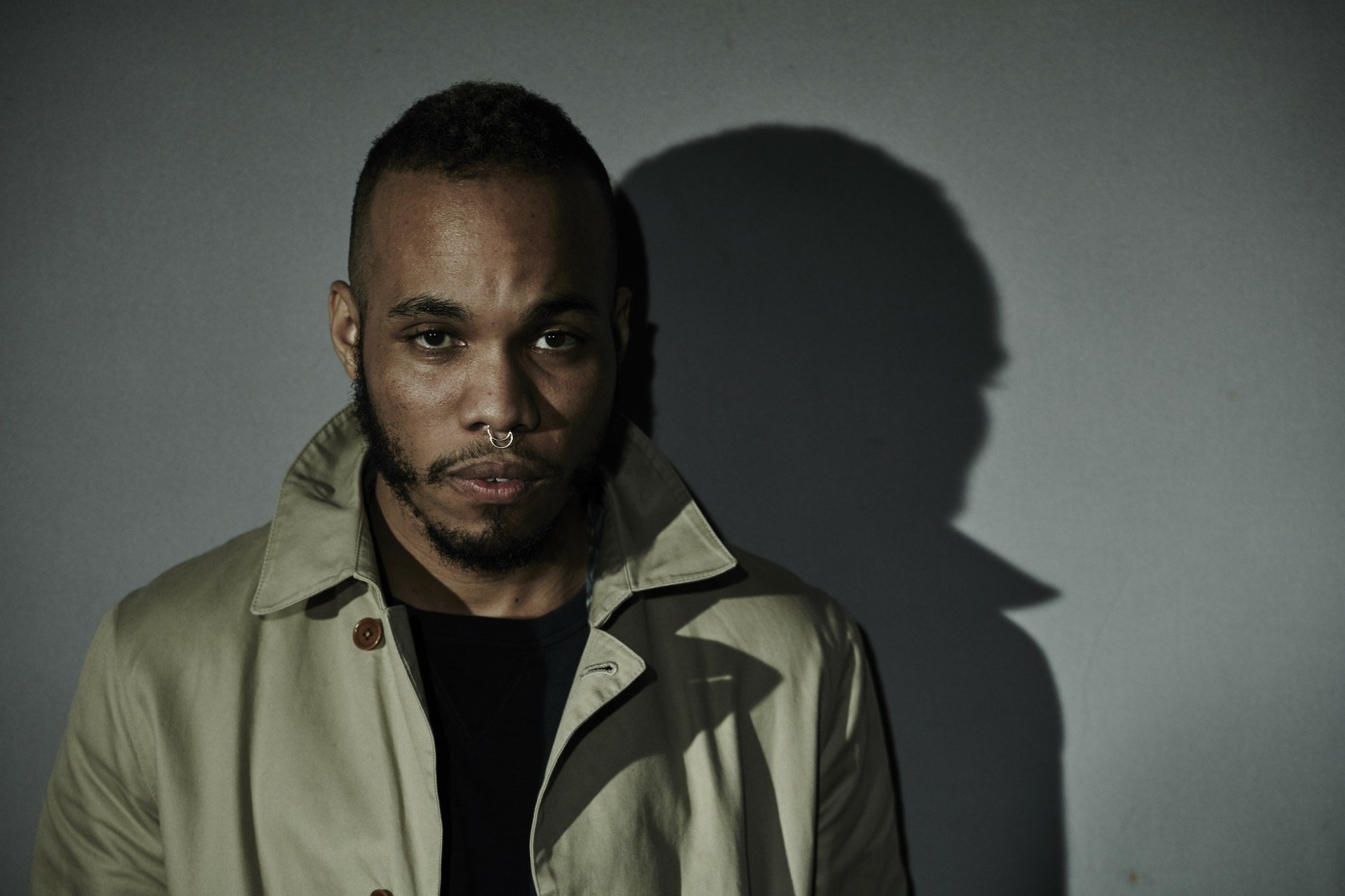 HD wallpaper featuring a moody portrait of a man with a shadow profile, tagged with Anderson .Paak.