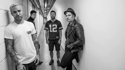 Black and white HD wallpaper featuring the members of Fall Out Boy posing in a hallway for a desktop background.