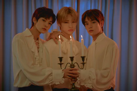 Three members of ENHYPEN pose together, holding a candelabrum, dressed in elegant white shirts, against a softly lit backdrop. A striking HD wallpaper celebrating music and artistry.