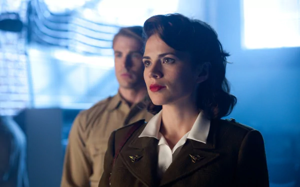 4K Ultra HD PC desktop wallpaper: Peggy Carter in WWII military uniform foreground, Captain America (Steve Rogers) blurred behind — scene from Captain America: The First Avenger.