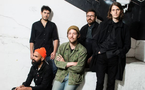 HD desktop wallpaper featuring the band Fleet Foxes, with members posing against a white wall.