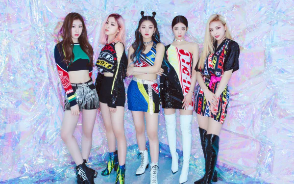 ITZY K-pop group posing for a vibrant HD desktop wallpaper with colorful outfits against a glittering background.