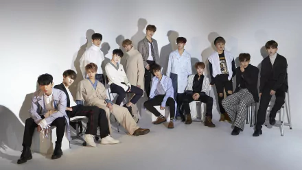 HD desktop wallpaper featuring a stylish group of thirteen individuals posing against a light background, tagged as Seventeen.