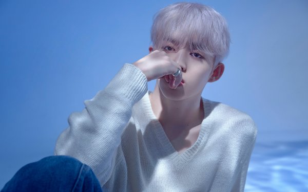 Stylish individual with light-colored hair posing in a serene blue setting, perfect as a Seventeen-themed HD desktop wallpaper and background.