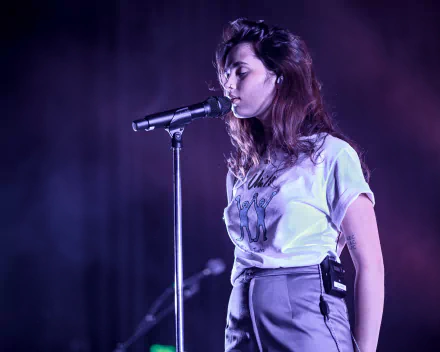 Female singer performing onstage in a HD desktop wallpaper, ideal background for music enthusiasts.