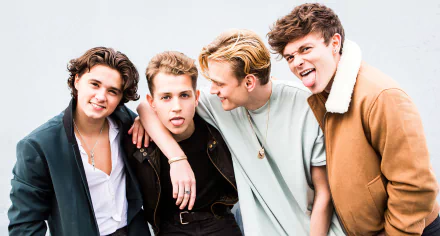 HD desktop wallpaper featuring The Vamps, with four band members playfully posing together against a light background.