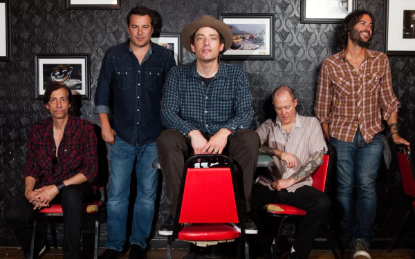 HD desktop wallpaper featuring a group of five men posing casually, tagged as The Wallflowers, with patterned wallpaper in the background.