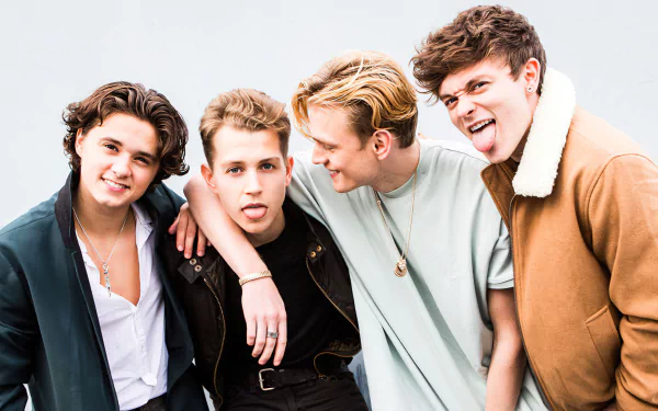 HD desktop wallpaper featuring The Vamps, with four band members playfully posing together against a light background.