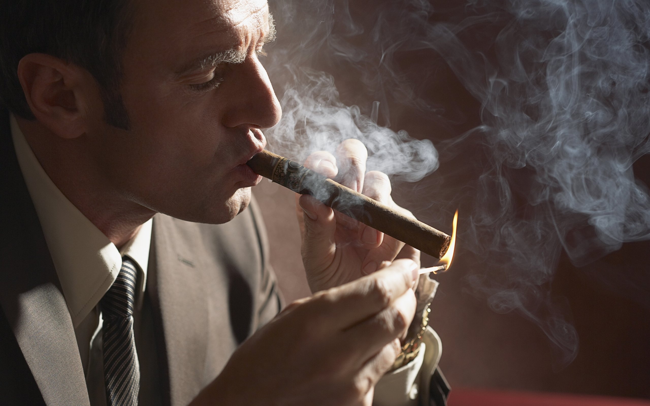 Smoking man enjoying a cigar - setting a moody vibe.