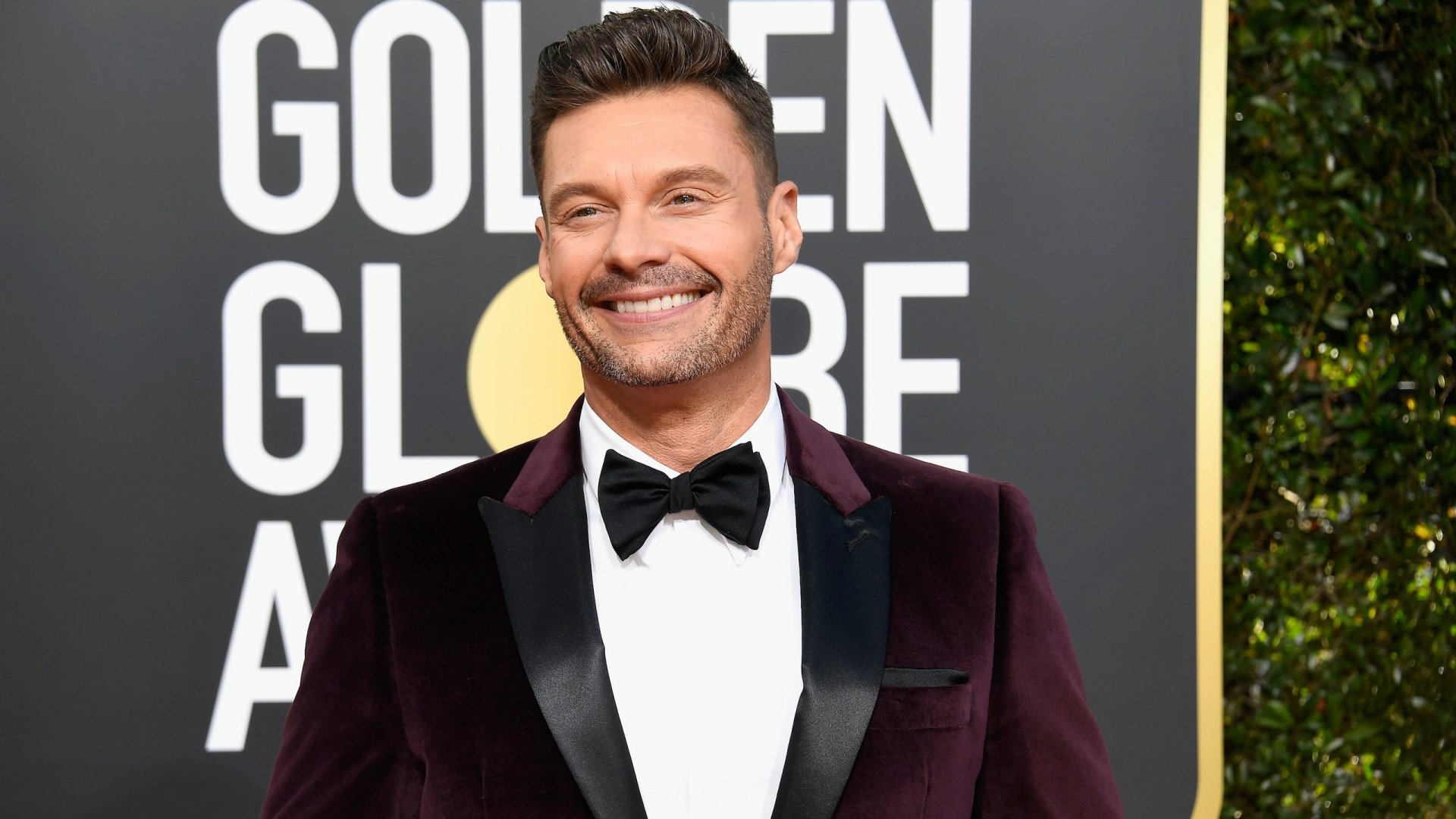 HD desktop wallpaper featuring a smiling person in a sharp tuxedo at the Golden Globe Awards.