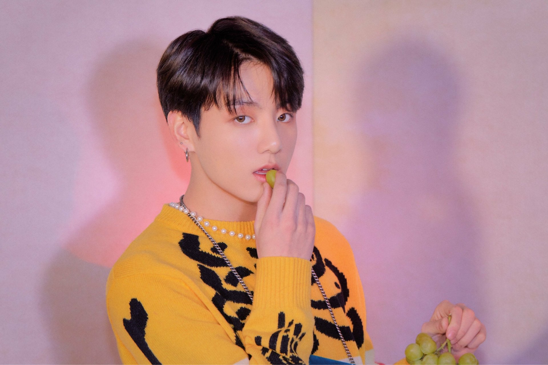 4K Ultra HD image of Jungkook, BTS singer, posing against a pastel background, showcasing K-pop style and music influence.