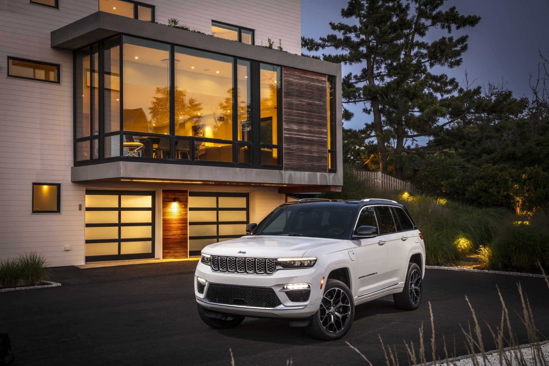 White Jeep Grand Cherokee Summit Reserve SUV parked at dusk in front of a modern home, 2K Quad HD PC desktop wallpaper and background.