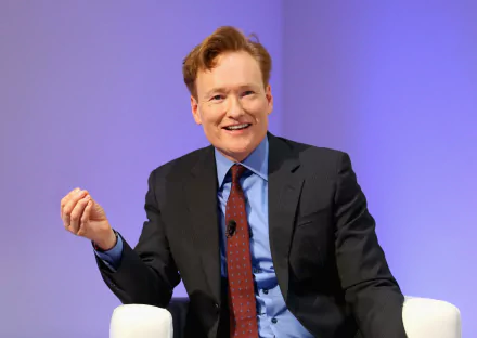 HD desktop wallpaper featuring a cheerful person in a business suit with a blue background, creating an engaging atmosphere for your screen.