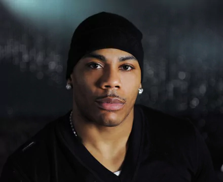 HD desktop wallpaper featuring a person with a beanie and earrings against a blurred urban background.