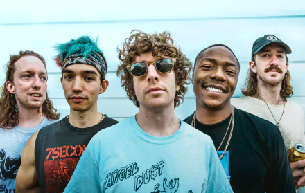 Group of happy young adults posing together for a vibrant HD desktop wallpaper with a turnstile theme.