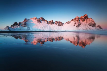 HD desktop wallpaper featuring the majestic Vestrahorn Mountain in Iceland, mirrored beautifully in a tranquil water surface at dusk.