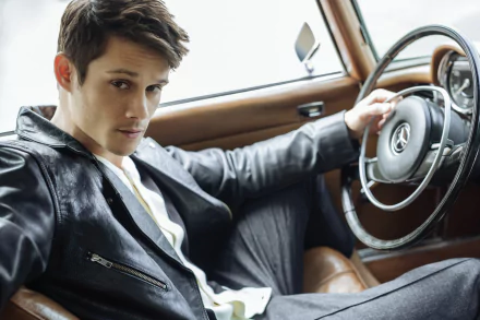 Stylish man in a leather jacket posing inside a classic car with wooden details, portraying a chic and sophisticated look for a high-definition desktop wallpaper and background.
