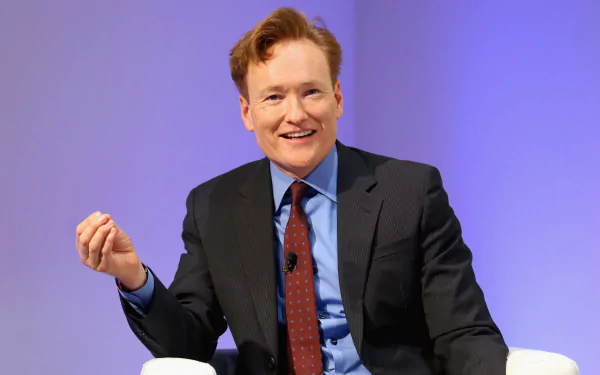 HD desktop wallpaper featuring a cheerful person in a business suit with a blue background, creating an engaging atmosphere for your screen.