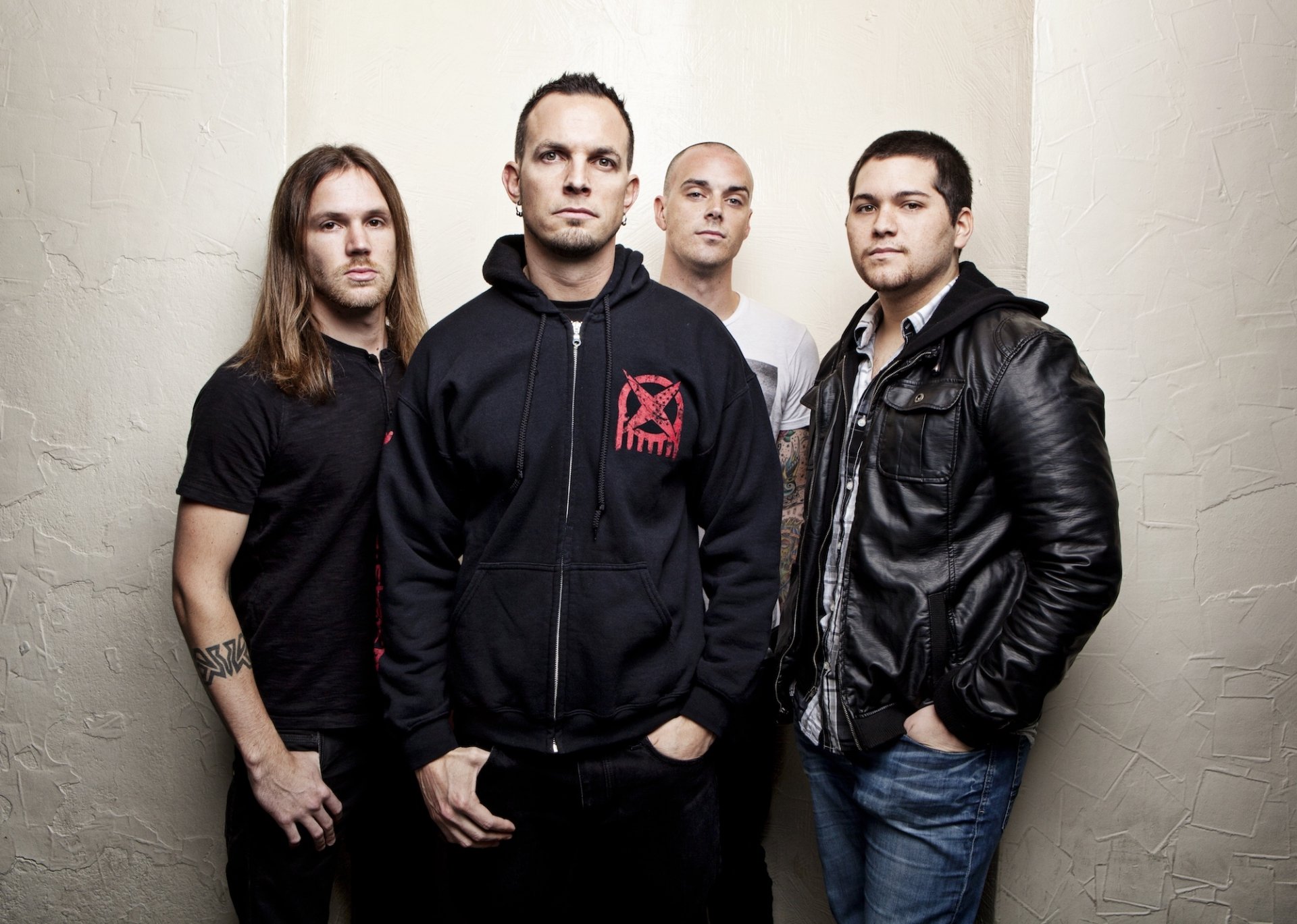 A striking HD desktop wallpaper featuring the band Tremonti, showcasing four members in a studio setting, exuding a powerful and intense music vibe.