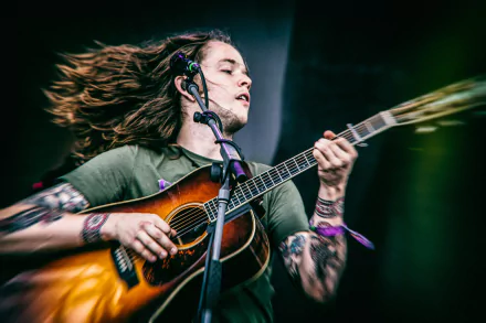 Dynamic HD wallpaper featuring a passionate guitarist in mid-performance, capturing the energy and emotion of live music.